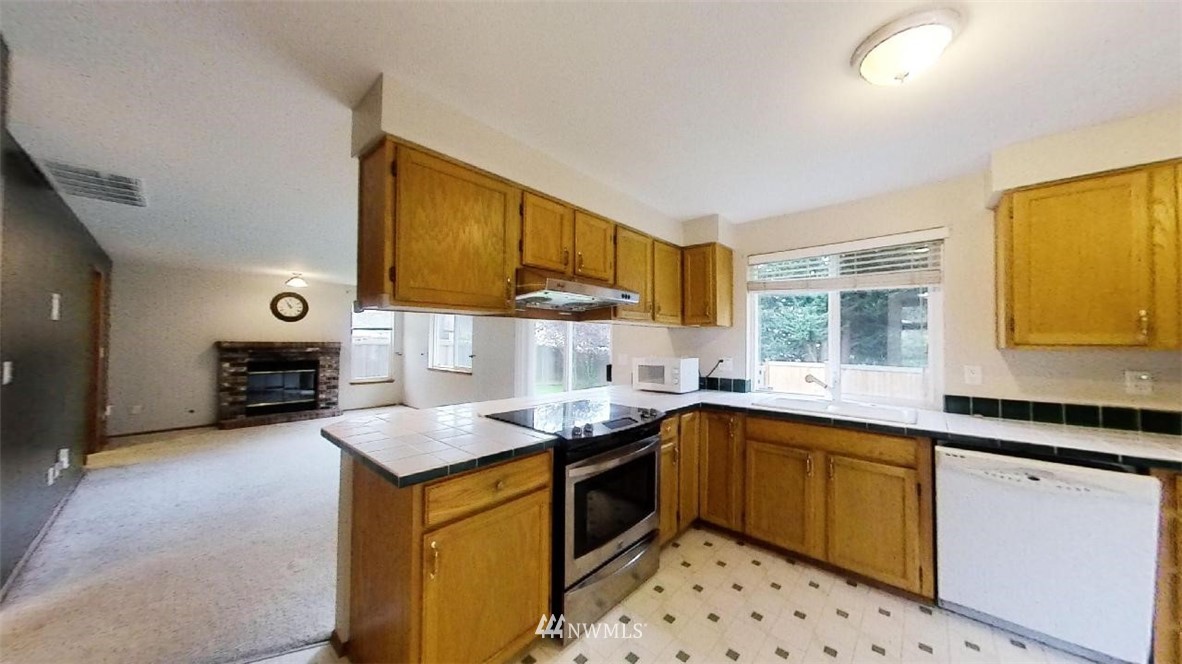 18607 104th Place Southeast Renton, WA 98055 - Photo 7 of 22 a kitchen with granite countertop a sink and counter top space