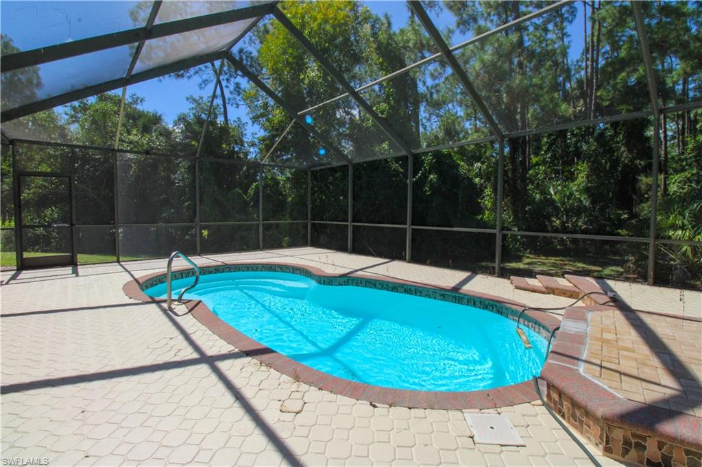 311 31st Street Northwest Naples, FL 34120 - Photo 13 of 50 a view of a swimming pool with a patio and yard of the house