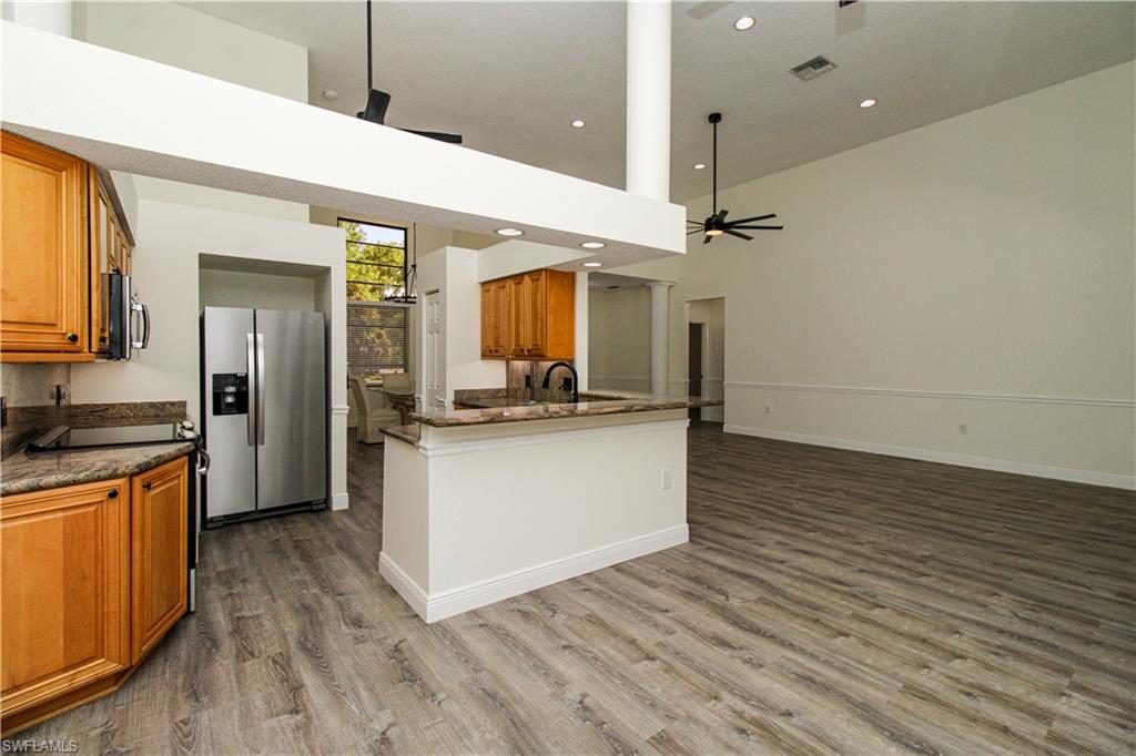311 31st Street Northwest Naples, FL 34120 - Photo 24 of 50 a kitchen with stainless steel appliances granite countertop a sink a stove top oven and wooden floor