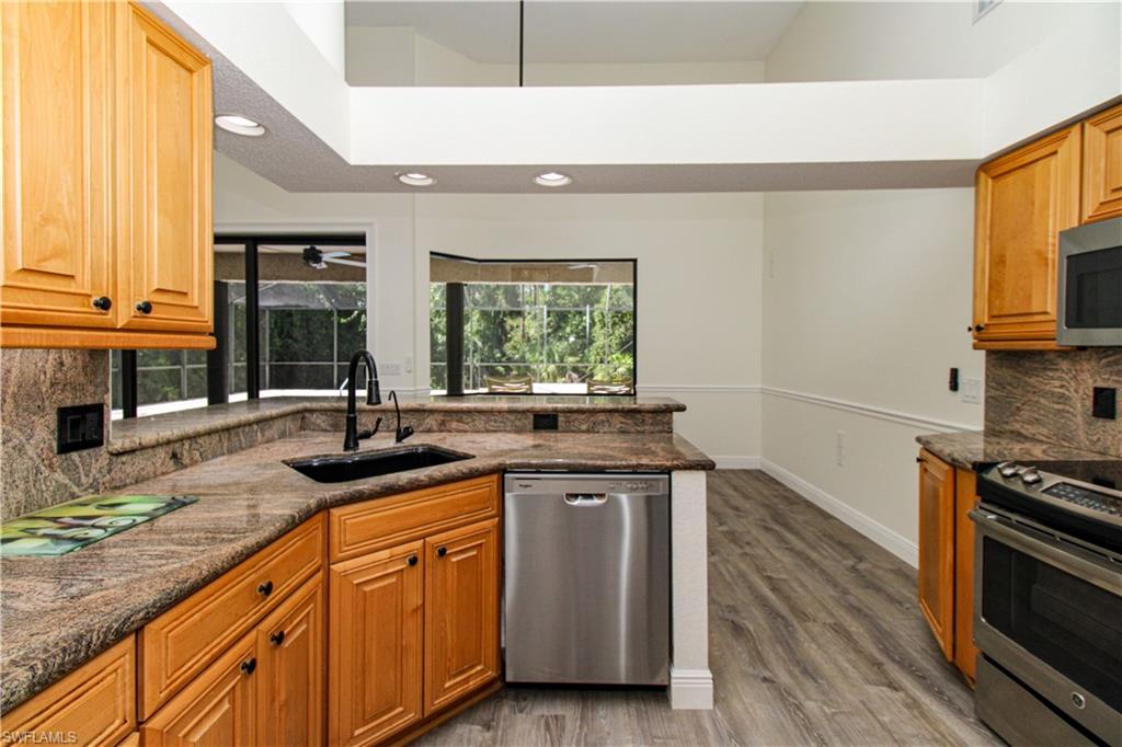 311 31st Street Northwest Naples, FL 34120 - Photo 26 of 50 a kitchen with stainless steel appliances granite countertop a sink stove and cabinets