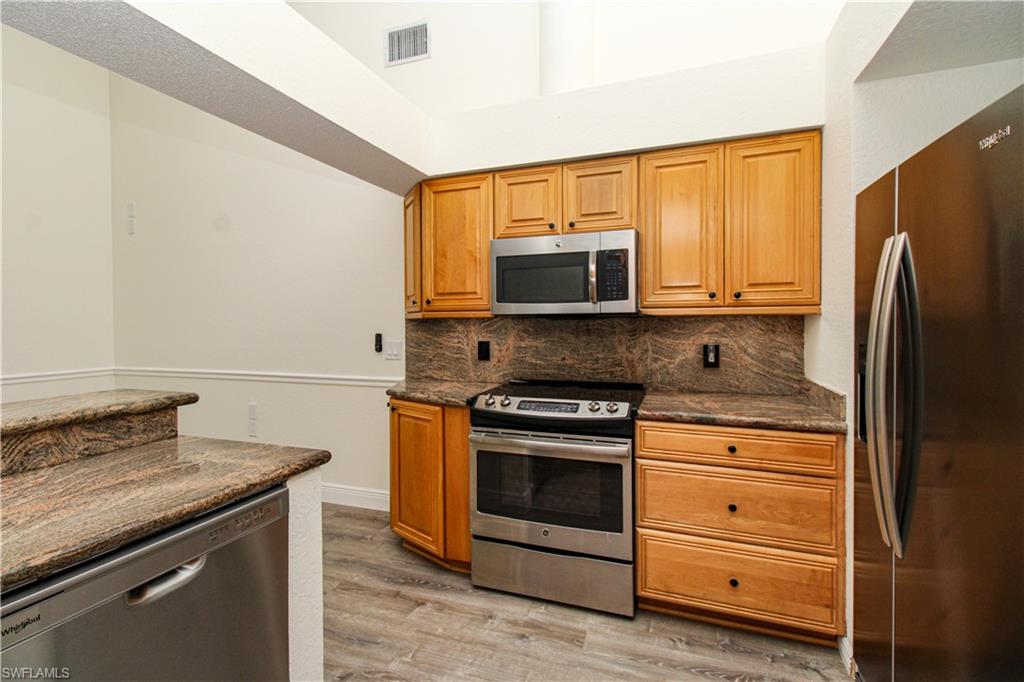 311 31st Street Northwest Naples, FL 34120 - Photo 28 of 50 a kitchen with stainless steel appliances granite countertop a stove microwave and refrigerator