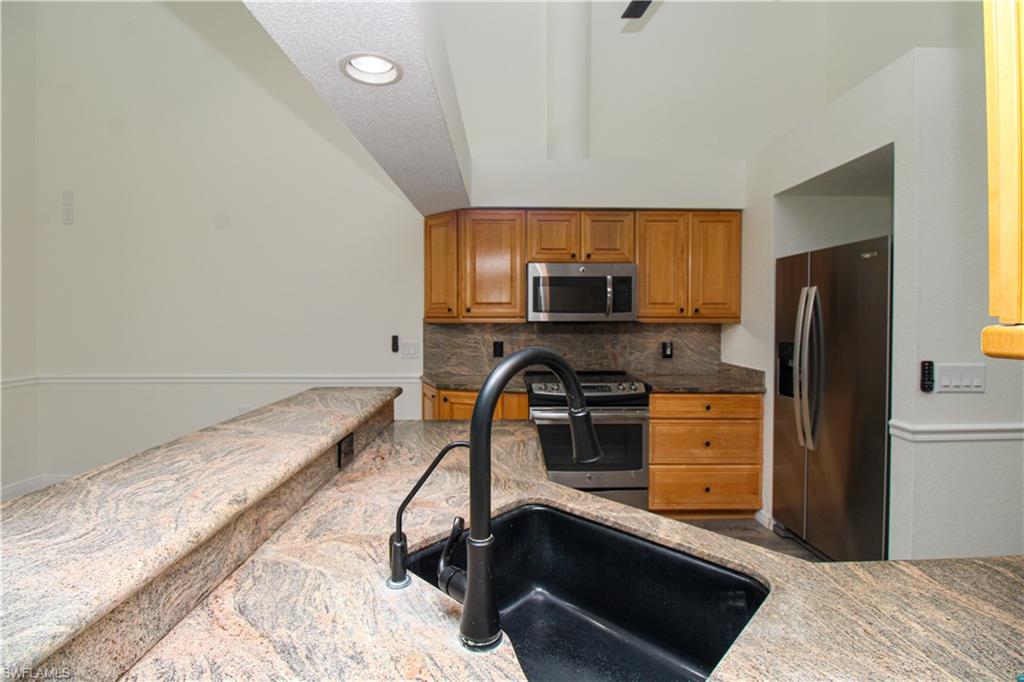 311 31st Street Northwest Naples, FL 34120 - Photo 29 of 50 a kitchen with stainless steel appliances a refrigerator stove microwave and sink
