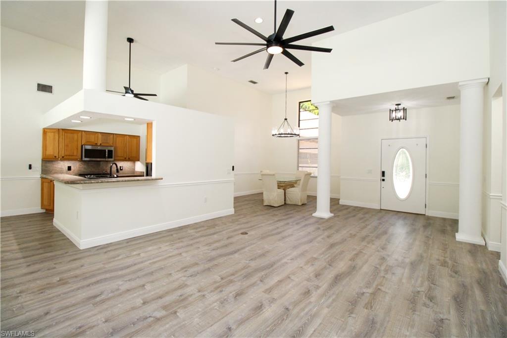 311 31st Street Northwest Naples, FL 34120 - Photo 3 of 50 a view of a kitchen with wooden floor and a ceiling fan