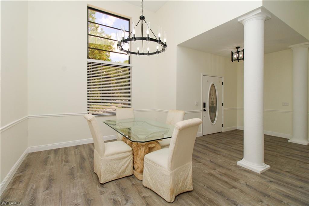 311 31st Street Northwest Naples, FL 34120 - Photo 31 of 50 a view of a dining room with furniture a chandelier and wooden floor