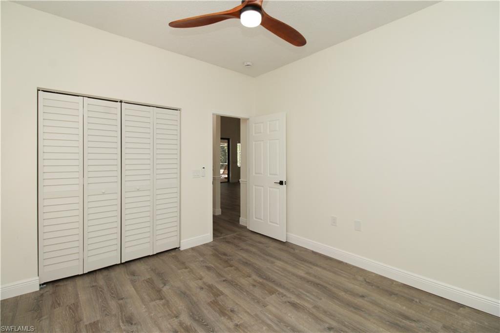 311 31st Street Northwest Naples, FL 34120 - Photo 40 of 50 an empty room with wooden floor closet and ceiling fan