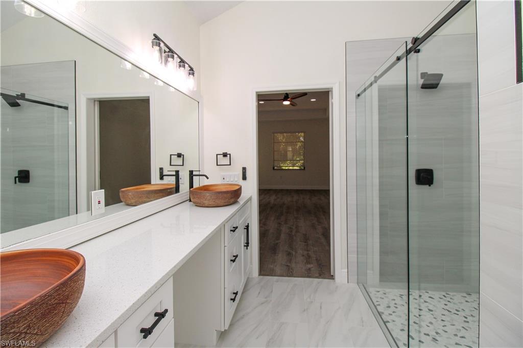 311 31st Street Northwest Naples, FL 34120 - Photo 48 of 50 a bathroom with a sink and a mirror