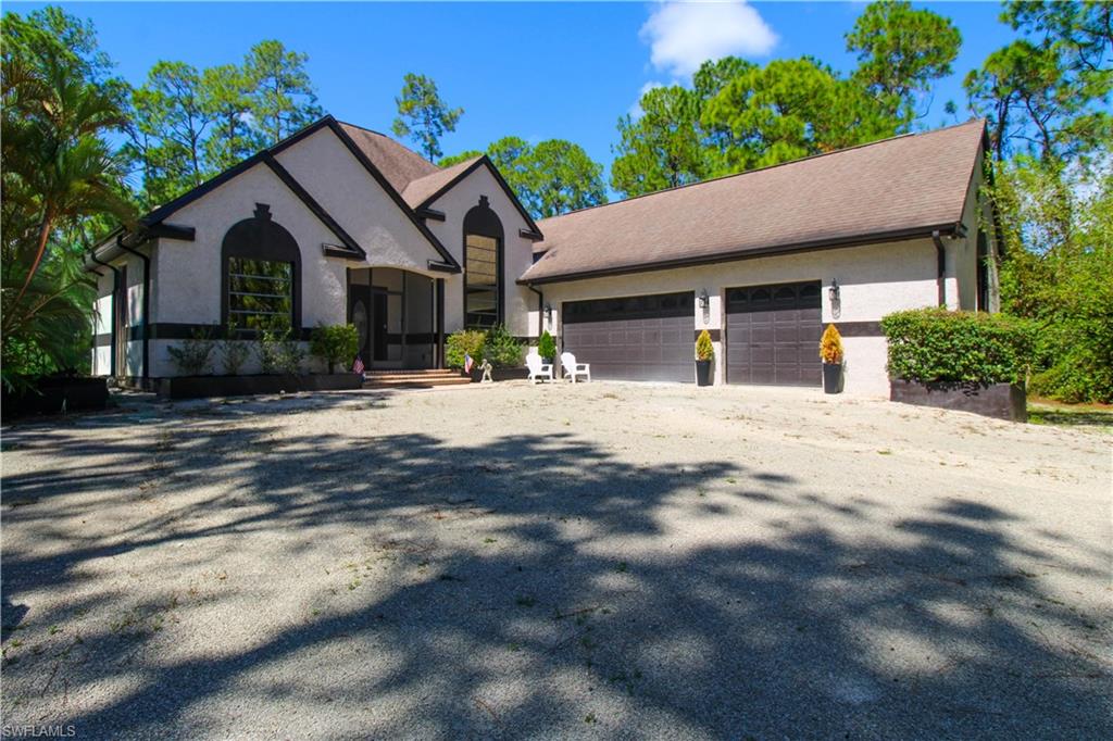 311 31st Street Northwest Naples, FL 34120 - Photo 8 of 50 a front view of a house with a yard