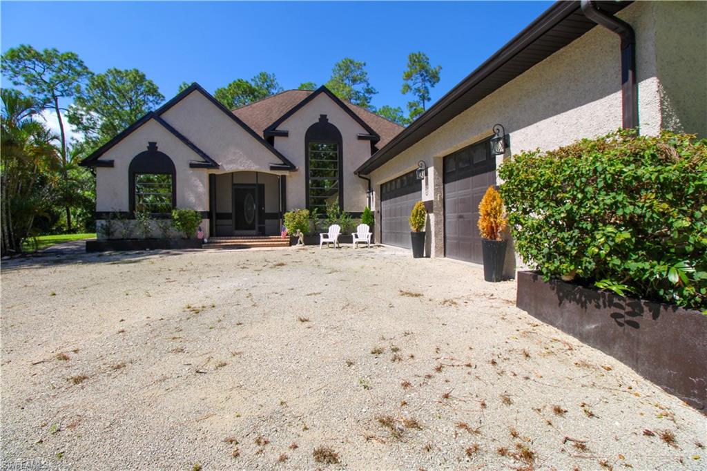 311 31st Street Northwest Naples, FL 34120 - Photo 9 of 50 a front view of a house with a yard