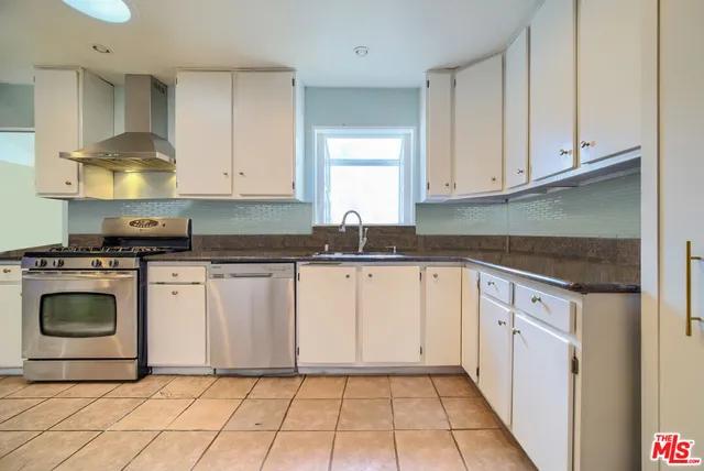 a kitchen with granite countertop white cabinets and white appliances