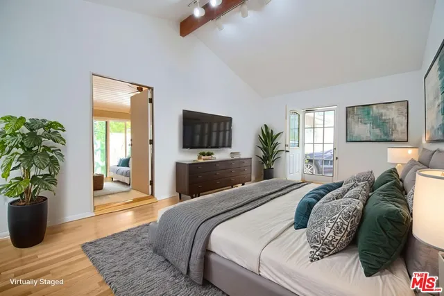 a bedroom with a bed and a potted plant