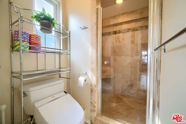 a bathroom with a toilet and a shower