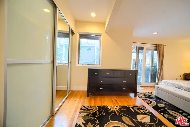 a bedroom with a bed and a dresser with mirror