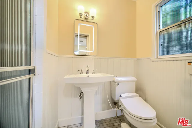 a bathroom with a toilet sink and mirror