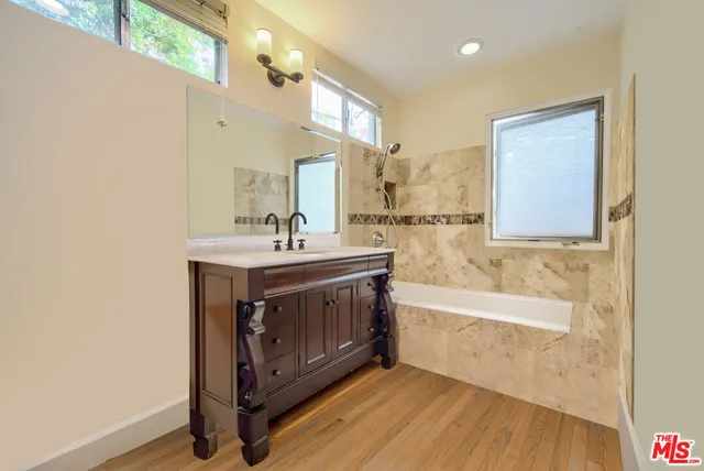 a bathroom with a sink mirror vanity and bathtub