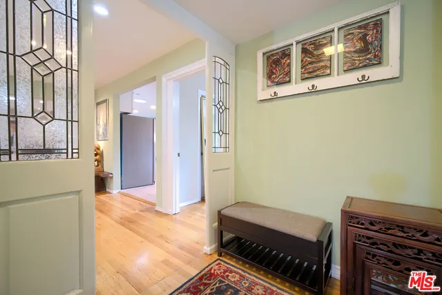 a view of a hallway with workspace and wooden floor