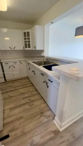 a kitchen with sink cabinets and wooden floor