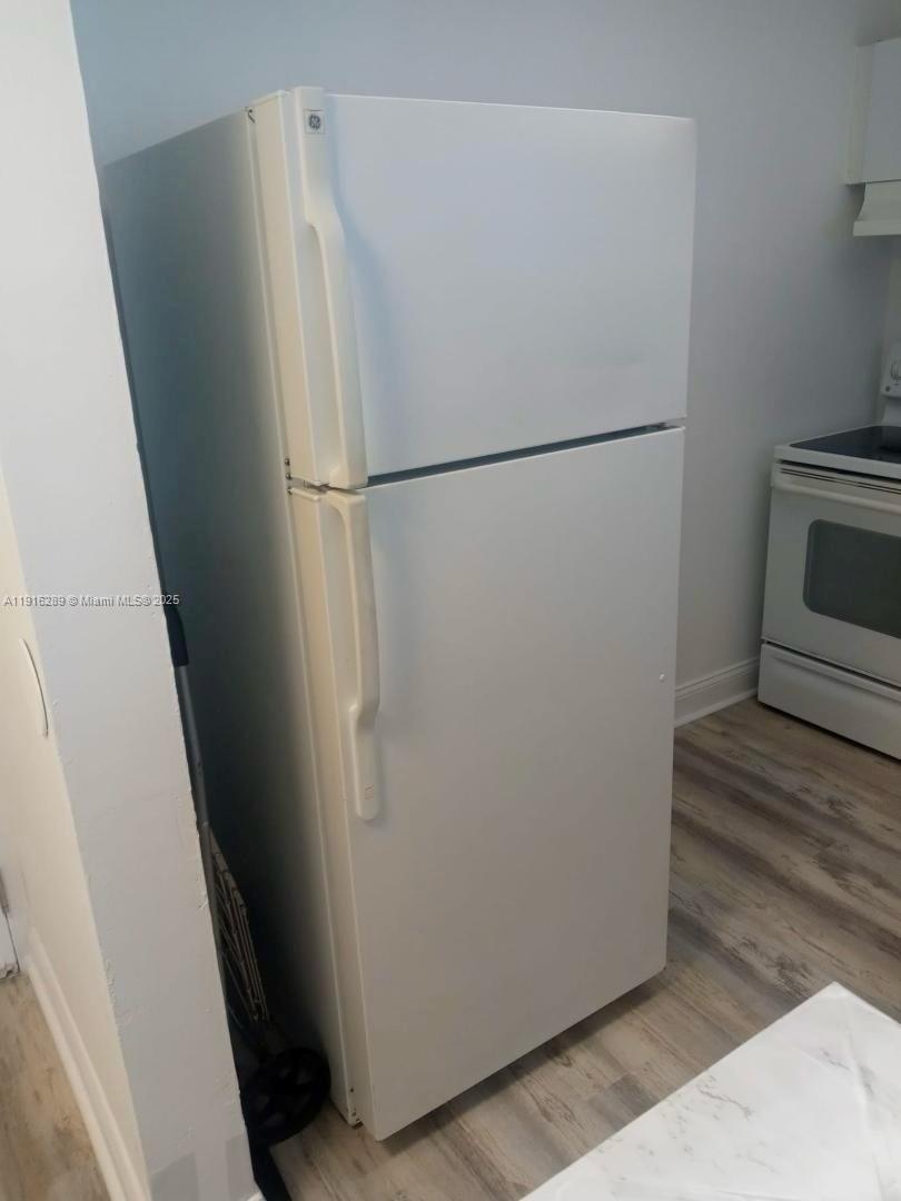 5201 Northwest 7th Street, Unit 405 Miami, FL 33126 - Photo 5 of 10 a white refrigerator freezer and a stove sitting inside of a kitchen