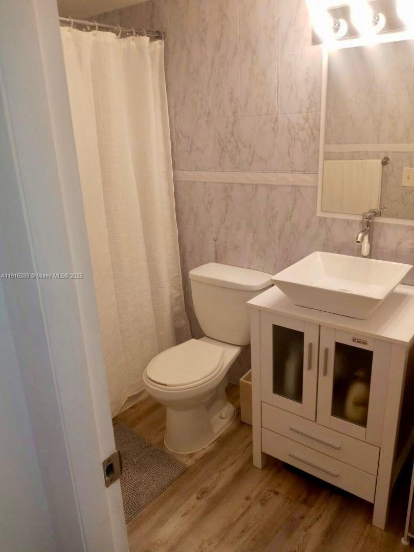 5201 Northwest 7th Street, Unit 405 Miami, FL 33126 - Photo 7 of 10 a white toilet sitting next to a white sink