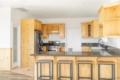 a kitchen with stainless steel appliances granite countertop a refrigerator and a sink