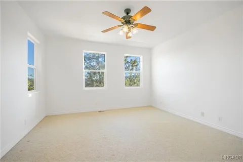 an empty room with a window and a fan