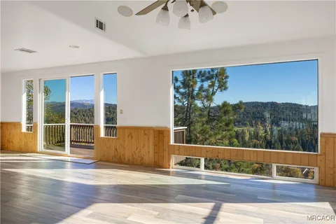 a view of a balcony with floor to ceiling windows and wooden floor