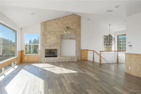 a view of empty room with wooden floor and fireplace