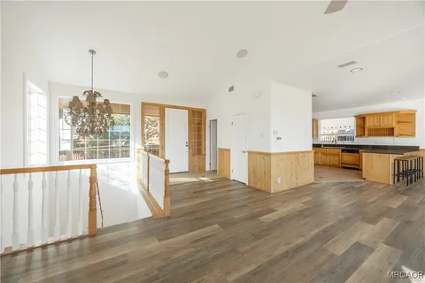 a view of a kitchen with kitchen island stainless steel appliances wooden floor and window