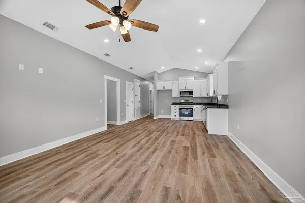a view of kitchen with wooden floor a sink and a refrigerator