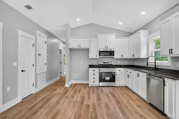 a kitchen with stainless steel appliances granite countertop a stove a sink and a refrigerator