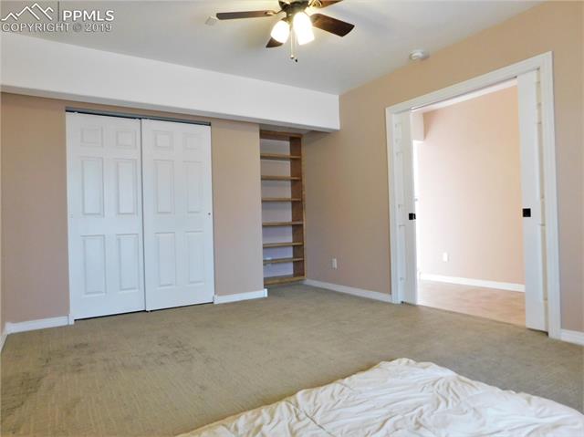 4320 Meridian Road Peyton, CO 80831 - Photo 16 of 28 2nd bedroom view 1, w shelves and French pocket doors