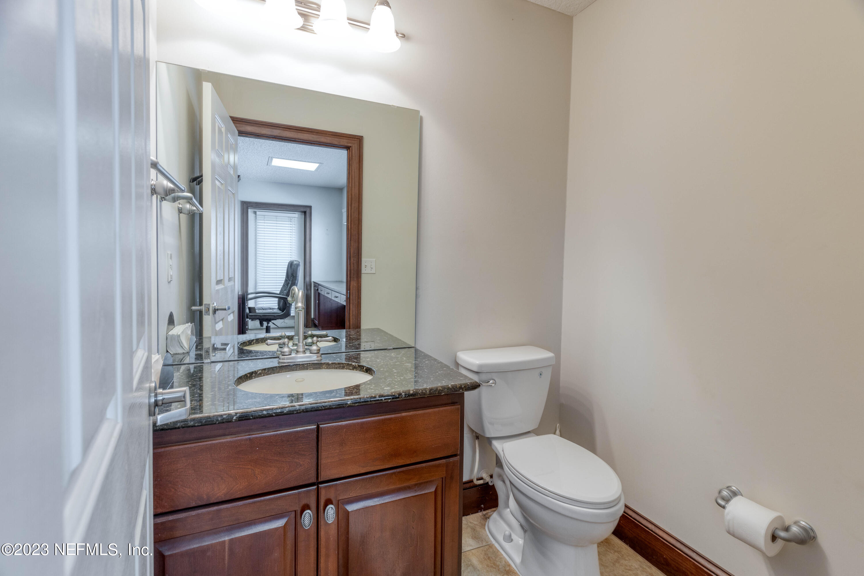 9636 Heckscher Drive Jacksonville, FL 32226 - Photo 26 of 43 a bathroom with a granite countertop toilet sink and mirror