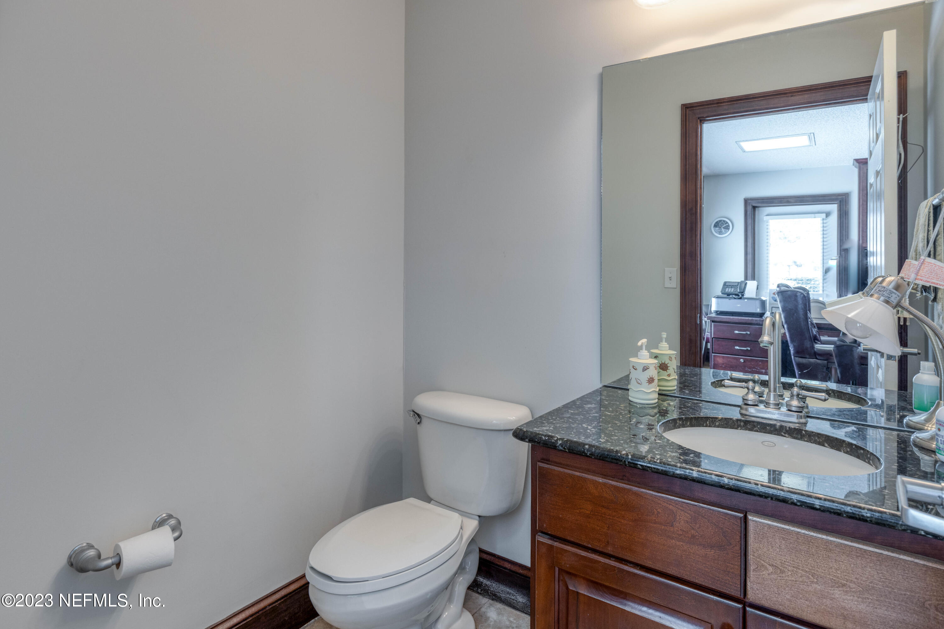 9636 Heckscher Drive Jacksonville, FL 32226 - Photo 28 of 43 a bathroom with a granite countertop toilet sink and mirror