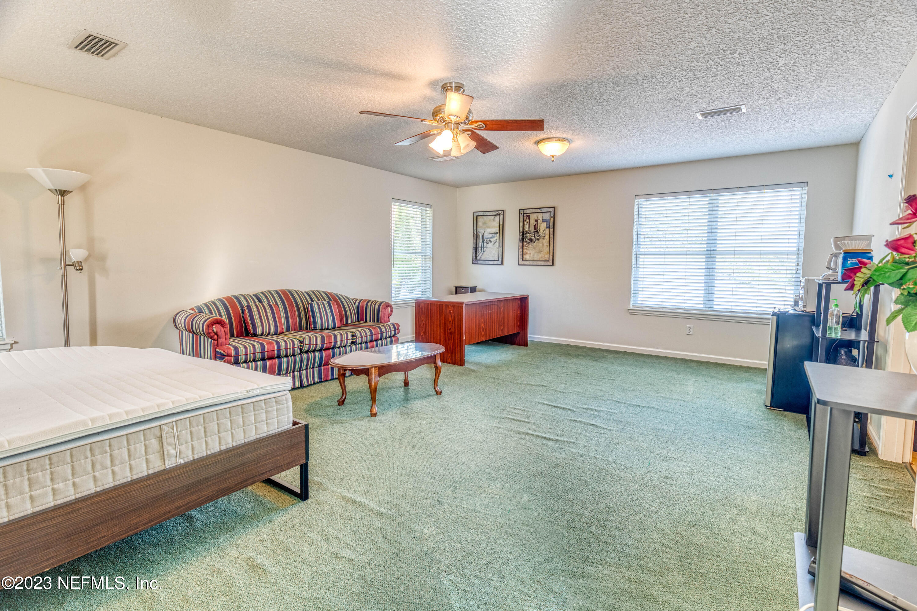 9636 Heckscher Drive Jacksonville, FL 32226 - Photo 40 of 43 a spacious bedroom with a bed and a chandelier