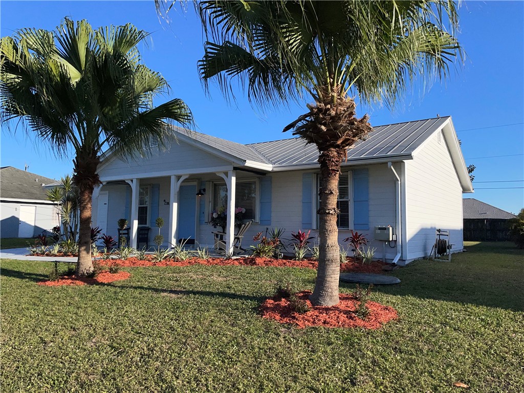 810 Southwest Commonwealth Road Port St. Lucie, FL 34953 - Photo 2 of 21 front view of a house with a yard and palm trees