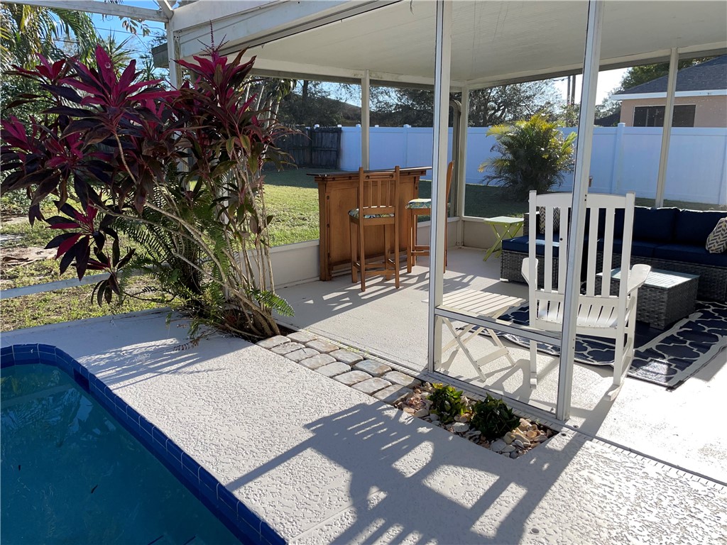 810 Southwest Commonwealth Road Port St. Lucie, FL 34953 - Photo 5 of 21 a view of a patio with table and chairs potted plants with wooden floor