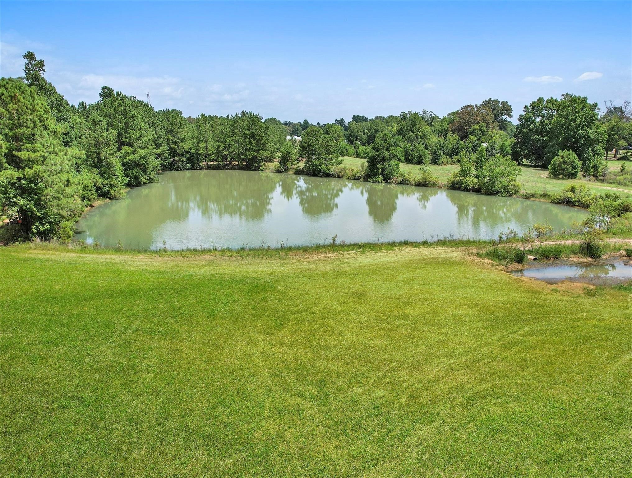11304 Fostoria Road Cleveland, TX 77328 - Photo 21 of 32 a view of a lake with houses in the back
