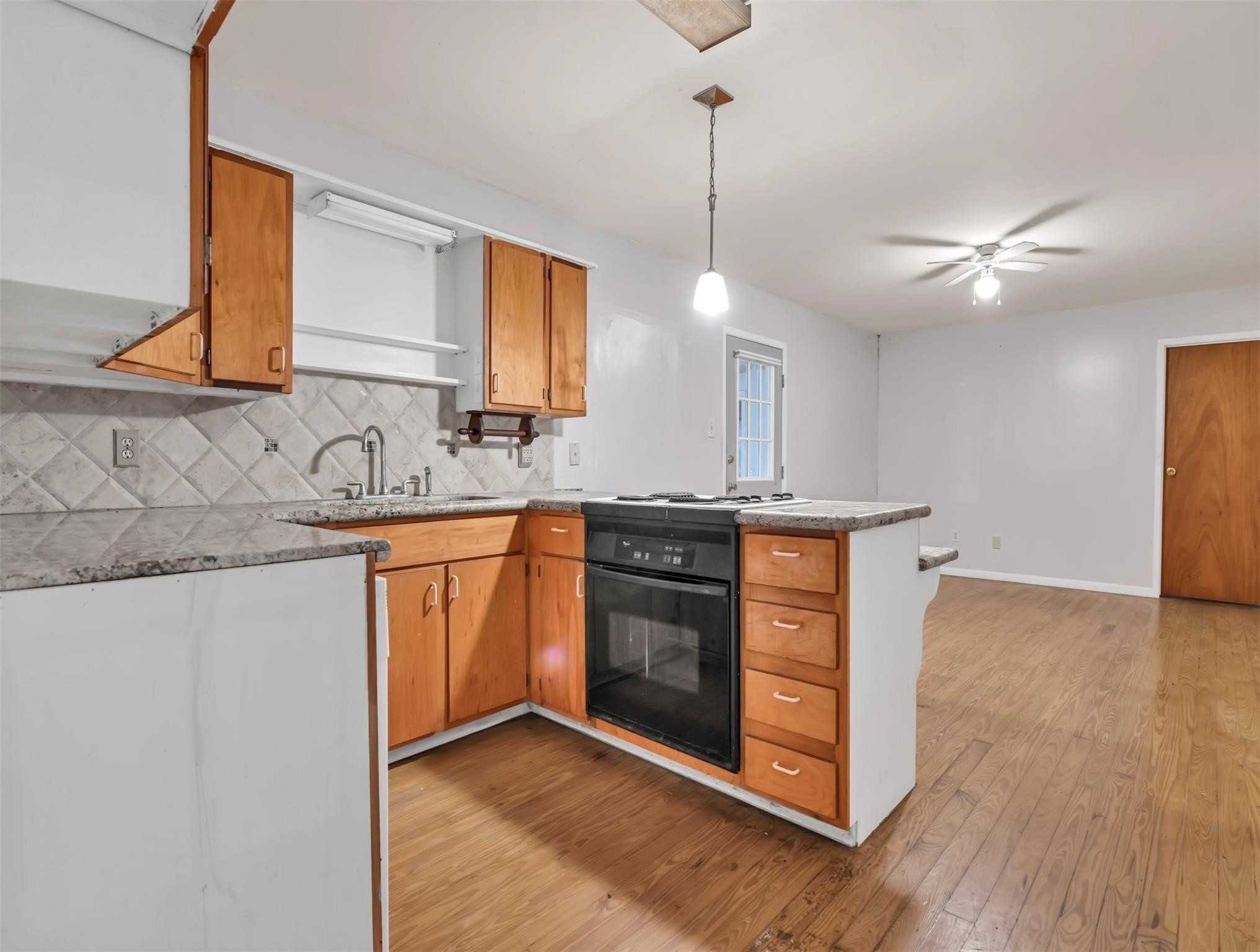 11304 Fostoria Road Cleveland, TX 77328 - Photo 6 of 32 a kitchen with stainless steel appliances granite countertop a sink a stove a refrigerator and island with wooden floor