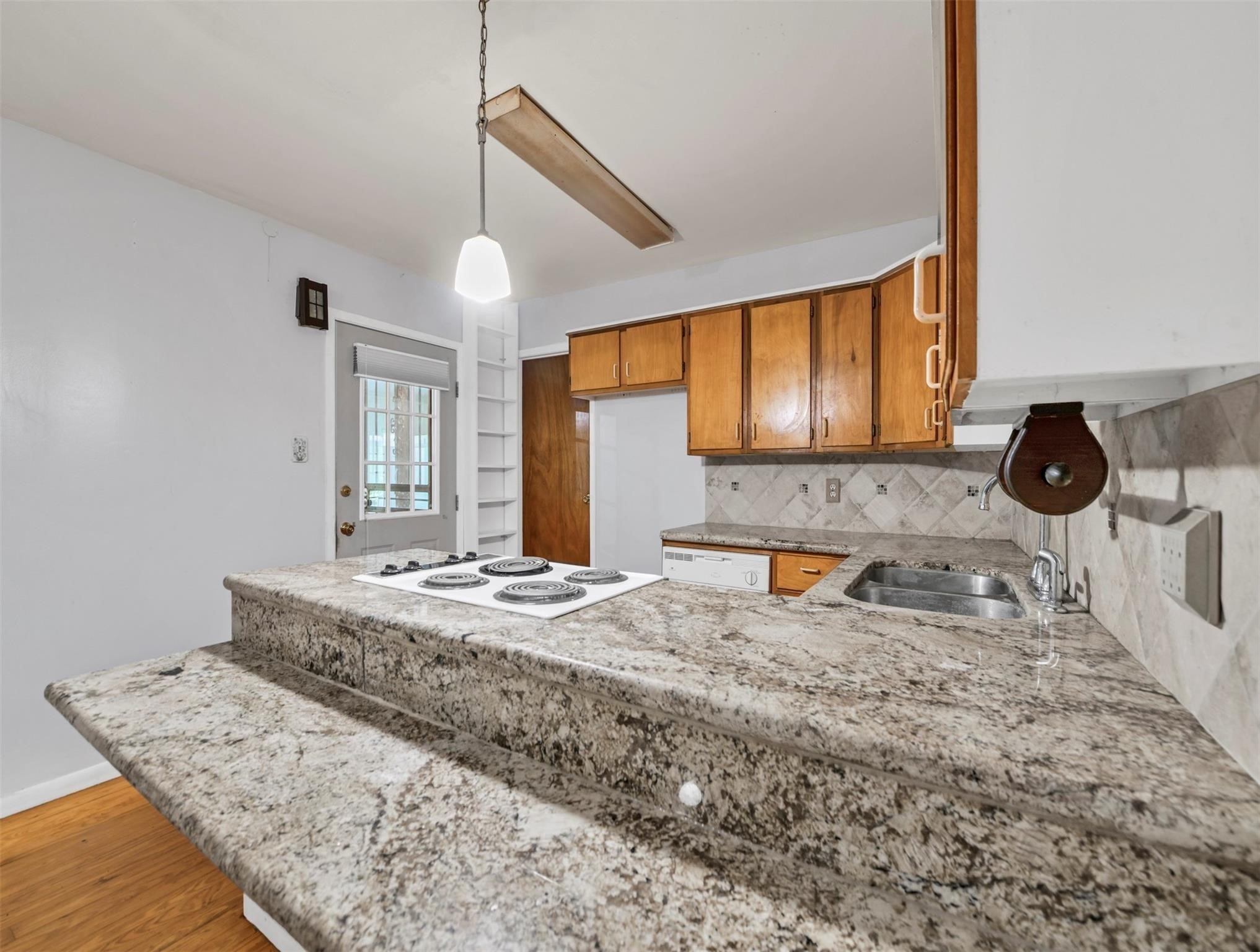 11304 Fostoria Road Cleveland, TX 77328 - Photo 7 of 32 a kitchen with a stove a sink and a wooden cabinets