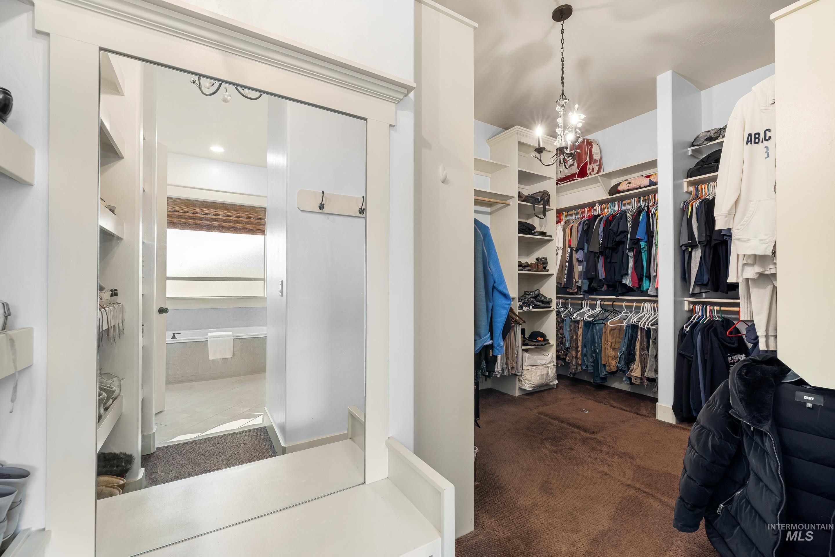 7521 North Grand Ridge Lane Eagle, ID 83616 - Photo 31 of 50 Walk in closet with a chandelier and dark carpet