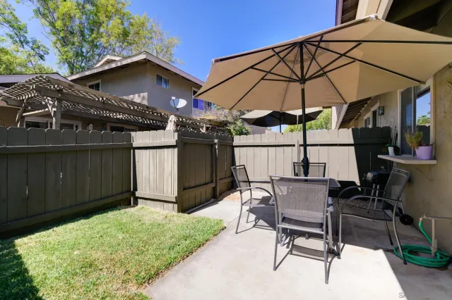 a view of a patio with a table and chairs under an umbrella