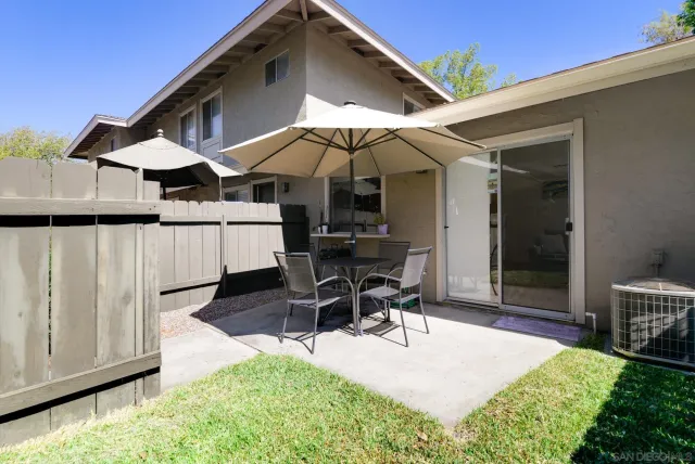 a patio with a table and chairs under an umbrella