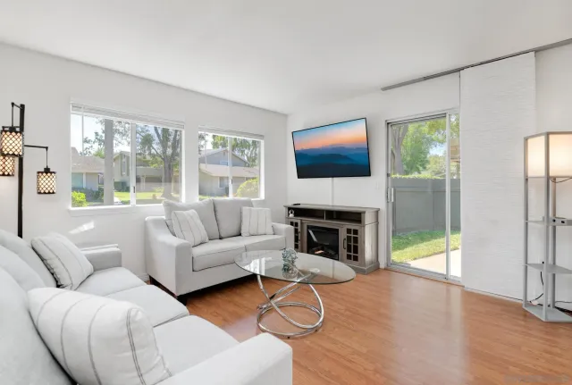 a living room with furniture a fireplace and a flat screen tv