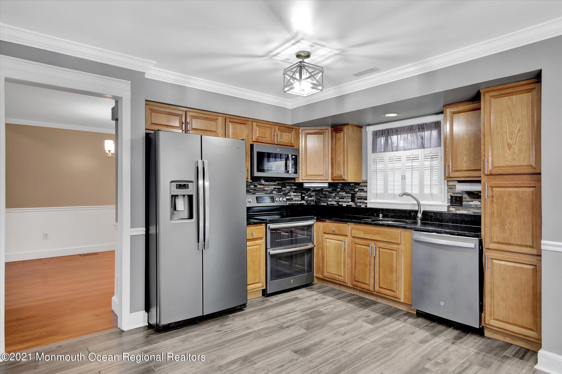 204 Schooner Road Manahawkin, NJ 08050 - Photo 8 of 34 a kitchen with stainless steel appliances granite countertop a refrigerator a stove a sink cabinets and wooden floor