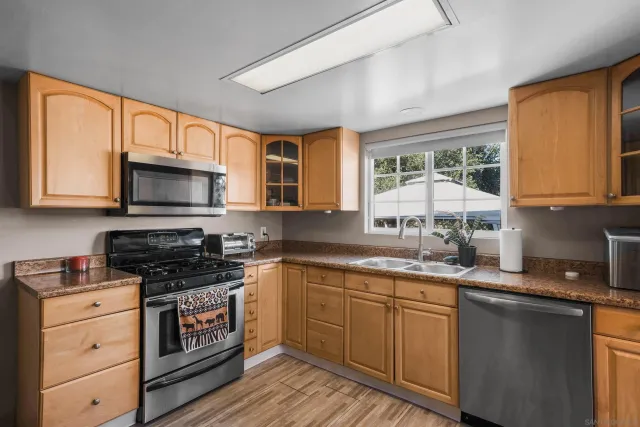 a kitchen with stainless steel appliances granite countertop a stove and a microwave
