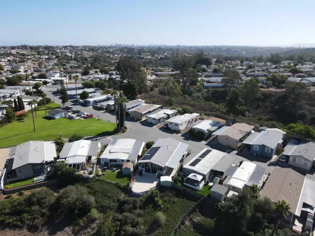 an aerial view of residential house with parking and trees
