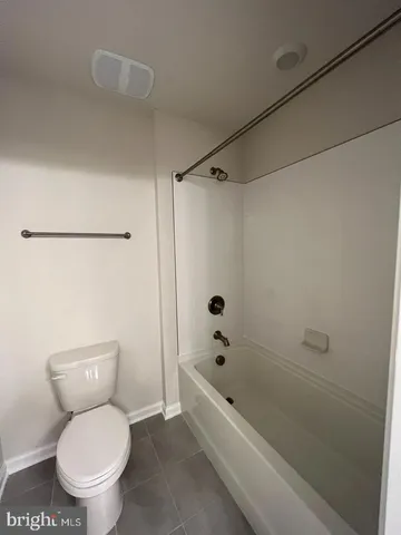 a white toilet sitting next to a bath tub