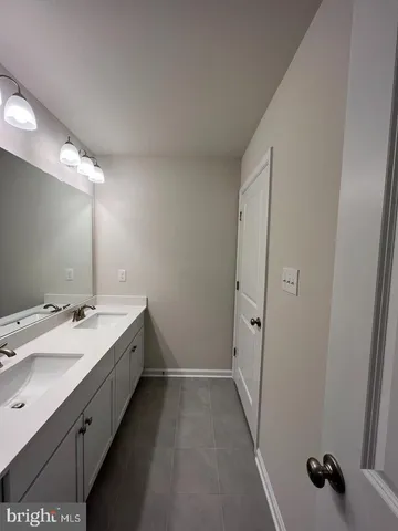a bathroom with a double vanity sink and mirror
