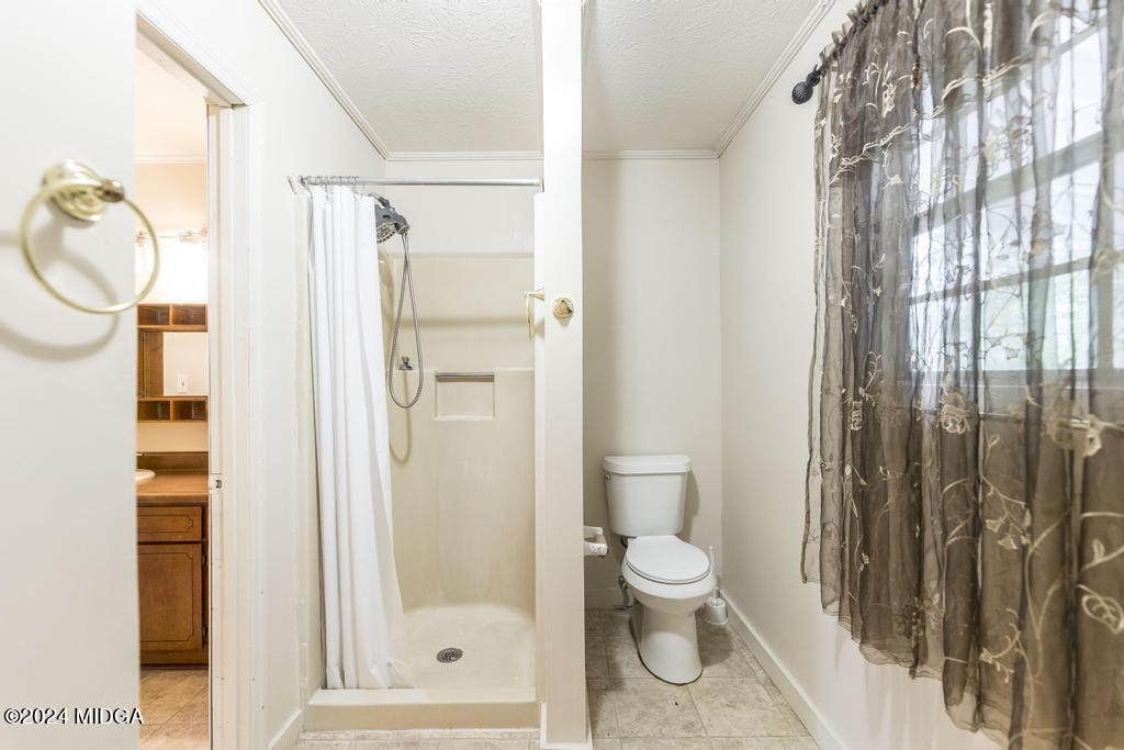 1400 Smith Chapel Road Musella, GA 31066 - Photo 16 of 28 a bathroom with a granite countertop shower a toilet and a shower