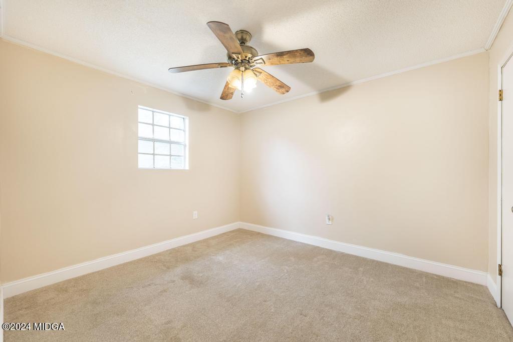 1400 Smith Chapel Road Musella, GA 31066 - Photo 17 of 28 an empty room with window and ceiling fan