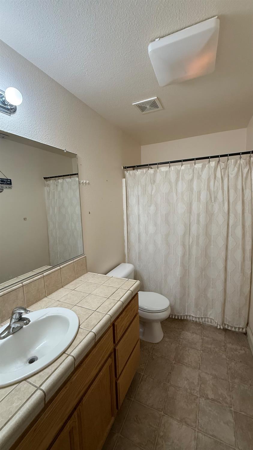 1416 San Rafael Street Los Banos, CA 93635 - Photo 15 of 21 a bathroom with a granite countertop sink and a mirror
